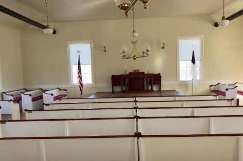 A church with many pews and flags on the walls