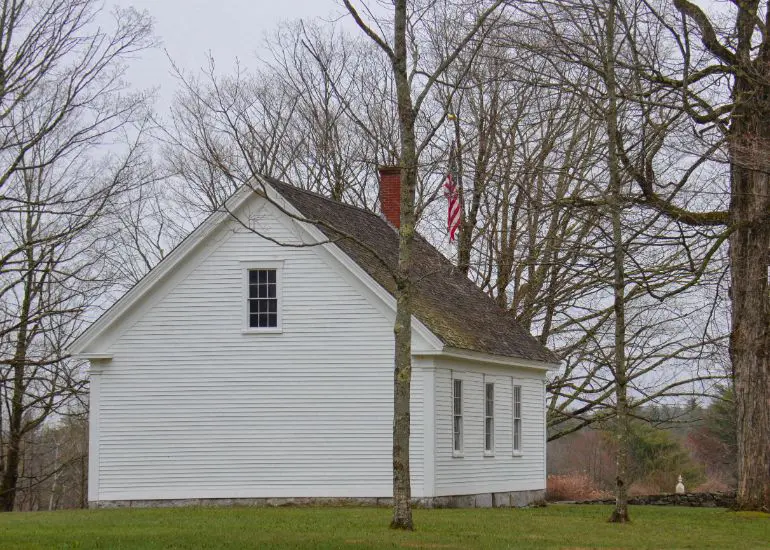 A white house with trees in the background