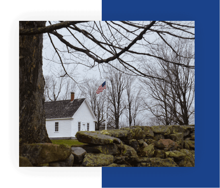 A white house sitting next to a tree.