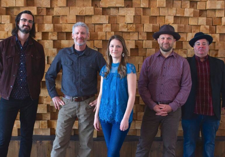 A group of people standing in front of a wall.